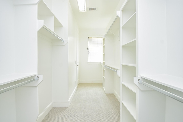 walk in closet featuring visible vents and light colored carpet