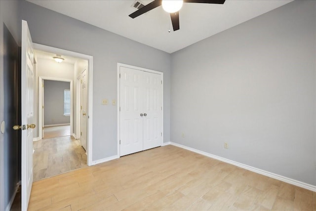 unfurnished bedroom featuring visible vents, baseboards, light wood-style flooring, a closet, and a ceiling fan