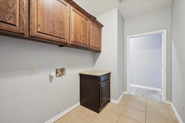 laundry area with hookup for a washing machine, light tile patterned flooring, cabinet space, and baseboards