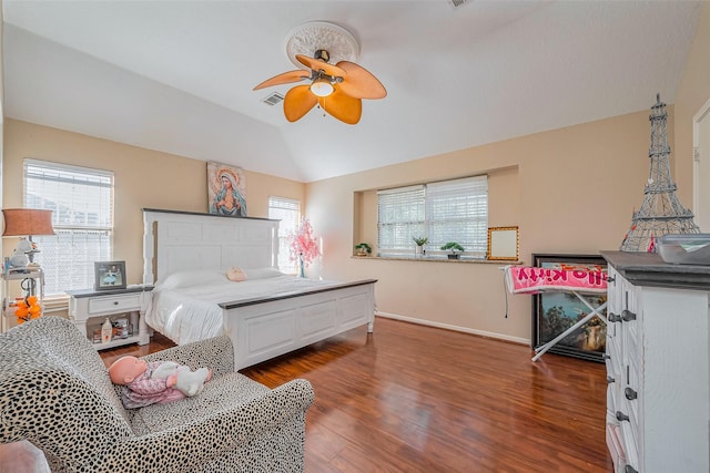 bedroom featuring multiple windows, lofted ceiling, baseboards, and wood finished floors