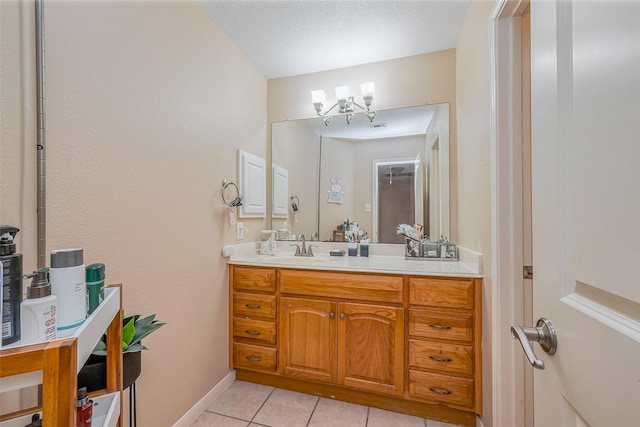 bathroom featuring tile patterned floors, baseboards, a textured ceiling, and vanity