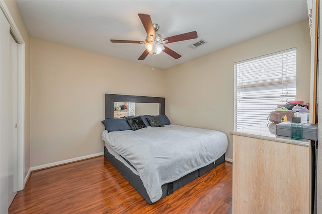 bedroom featuring visible vents, wood finished floors, a closet, baseboards, and ceiling fan