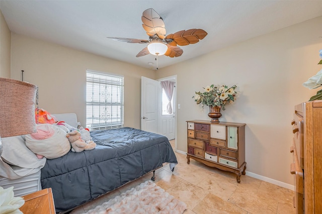 bedroom with ceiling fan and baseboards