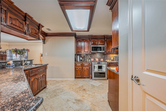 kitchen with baseboards, a sink, decorative backsplash, stainless steel appliances, and crown molding