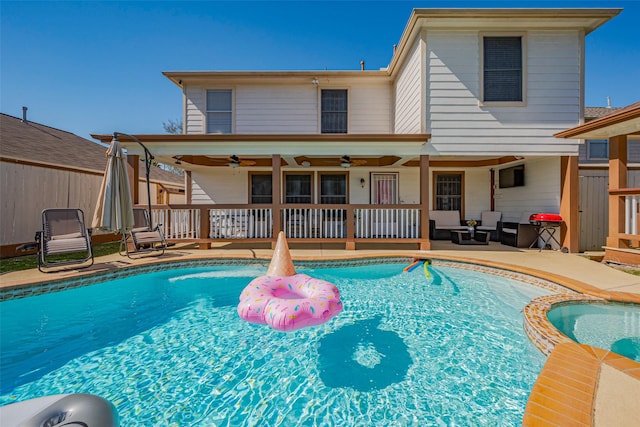 rear view of property featuring a patio, ceiling fan, and a pool with connected hot tub