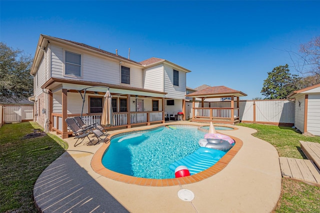 rear view of property with a gazebo, a yard, a fenced backyard, and a gate