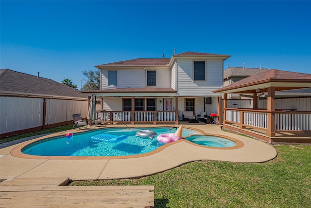 view of swimming pool featuring a fenced in pool, an in ground hot tub, a wooden deck, and fence