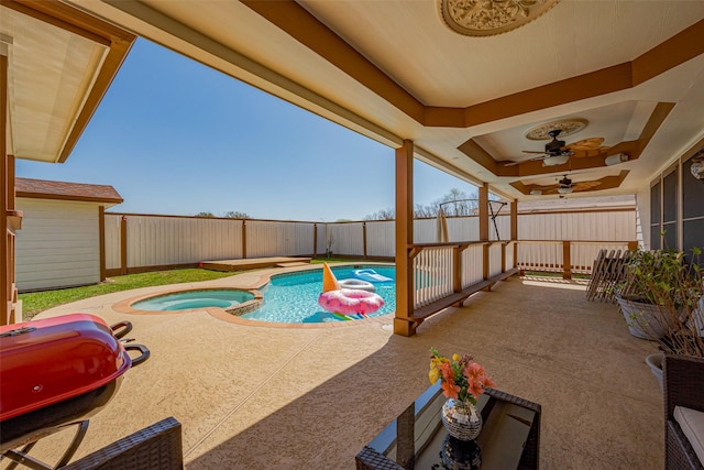 view of swimming pool featuring a patio area, a pool with connected hot tub, a ceiling fan, and a fenced backyard