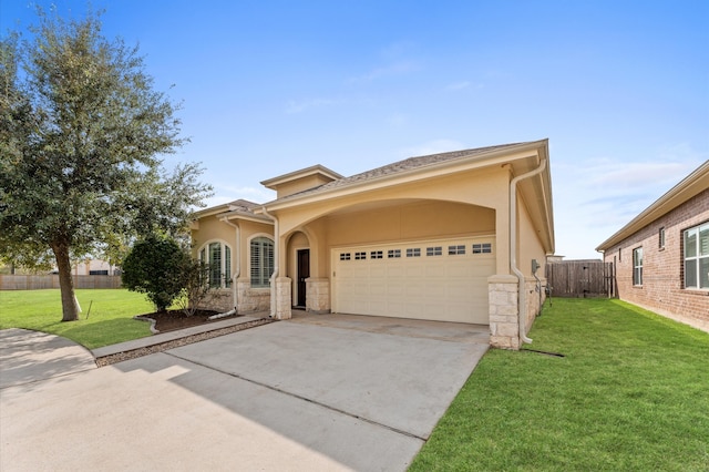 view of front facade featuring a front yard, fence, driveway, and stucco siding