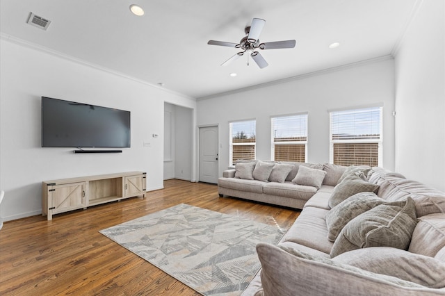 living area featuring recessed lighting, visible vents, wood finished floors, and crown molding