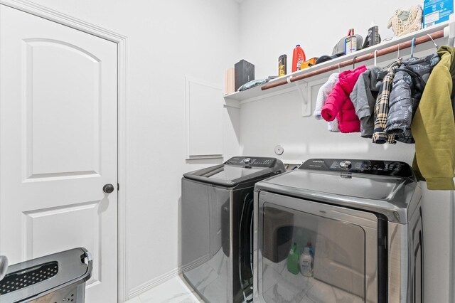 washroom with laundry area, marble finish floor, and washing machine and clothes dryer