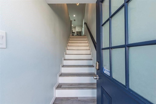 staircase featuring baseboards and wood finished floors