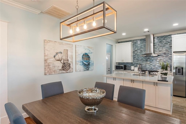dining space with crown molding, recessed lighting, wood finished floors, and visible vents