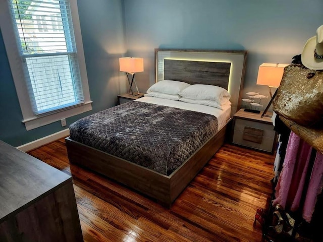 bedroom with wood finished floors and baseboards