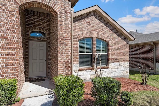 view of exterior entry featuring brick siding