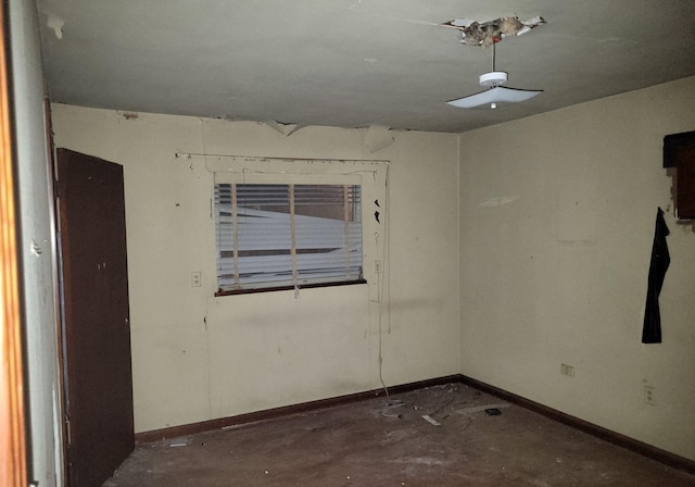 empty room with baseboards and unfinished concrete flooring