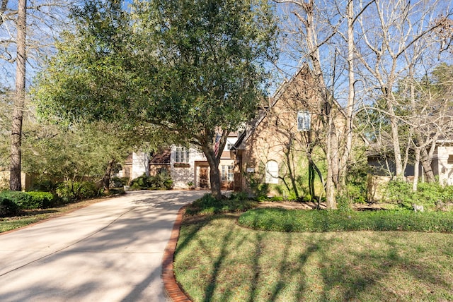 tudor-style house with concrete driveway