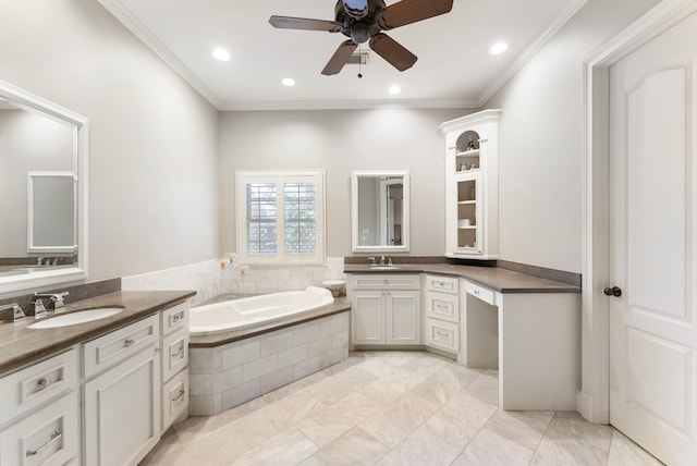 bathroom featuring a bath, ornamental molding, two vanities, and a sink