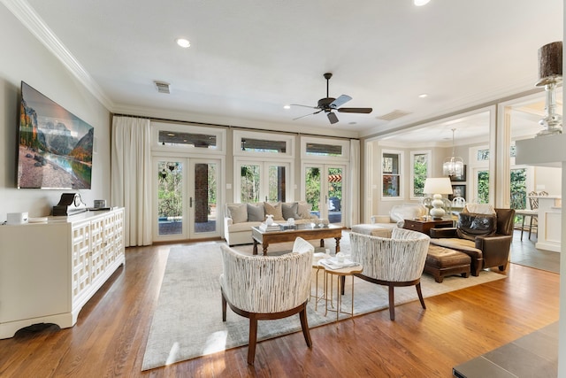 living area featuring wood finished floors, crown molding, french doors, and a wealth of natural light