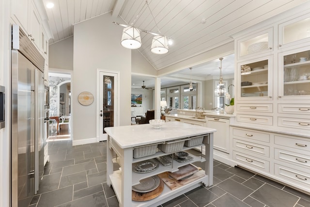 kitchen featuring open shelves, a sink, built in fridge, arched walkways, and white dishwasher