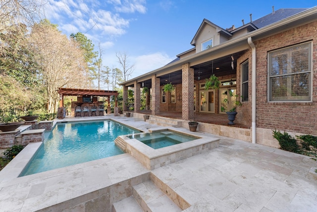 view of pool with outdoor dry bar, a pool with connected hot tub, a patio, and a pergola