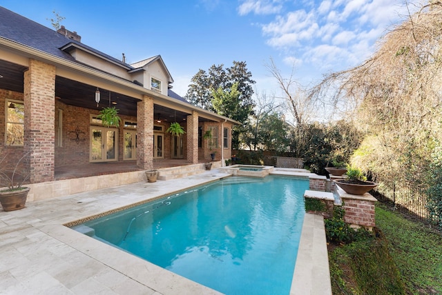 view of swimming pool with a patio, a ceiling fan, fence, and a pool with connected hot tub