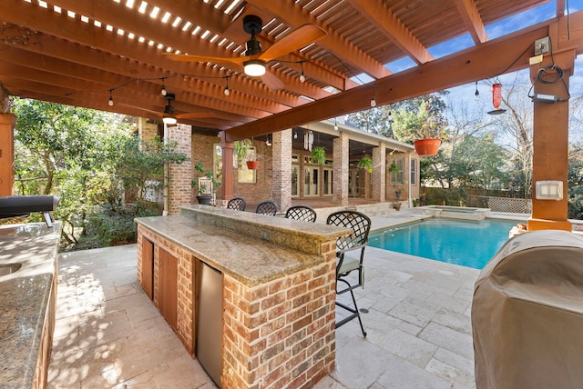 view of pool with a ceiling fan, fence, outdoor wet bar, a pergola, and a patio area