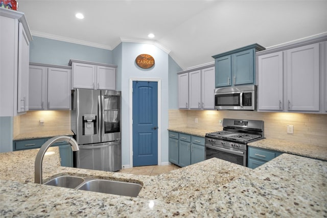 kitchen featuring crown molding, light stone countertops, decorative backsplash, stainless steel appliances, and a sink