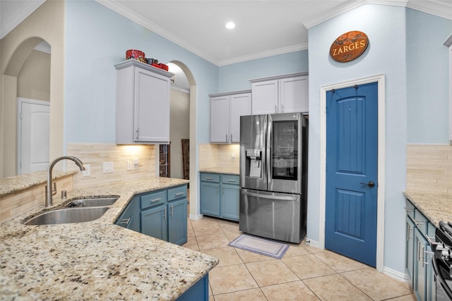 kitchen featuring ornamental molding, stainless steel refrigerator with ice dispenser, a sink, light tile patterned flooring, and light stone countertops