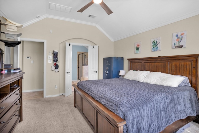 bedroom with light carpet, visible vents, arched walkways, and lofted ceiling