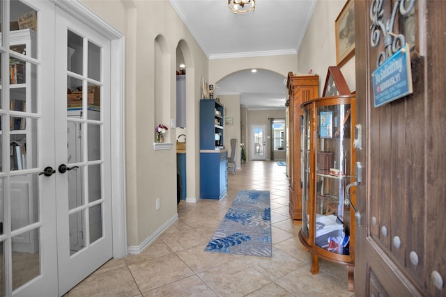 hallway featuring light tile patterned floors, french doors, arched walkways, and ornamental molding