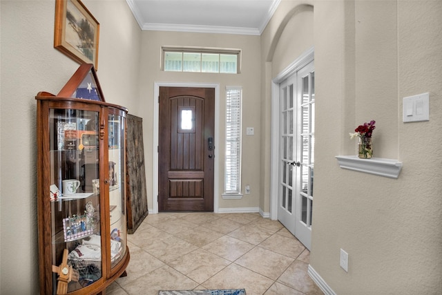 tiled foyer featuring french doors, baseboards, and ornamental molding