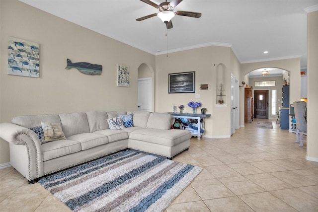 living area with arched walkways, baseboards, and light tile patterned flooring