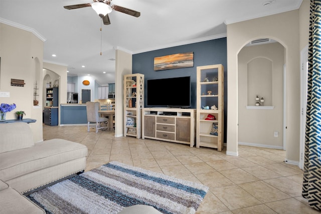 tiled living area with ceiling fan, arched walkways, and ornamental molding