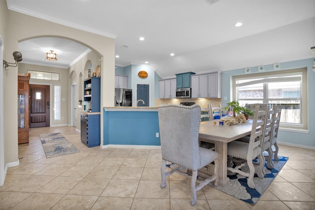 dining space with light tile patterned floors, recessed lighting, arched walkways, and ornamental molding