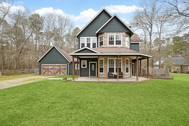 view of front facade featuring stone siding, fence, an outdoor structure, a front yard, and a shingled roof