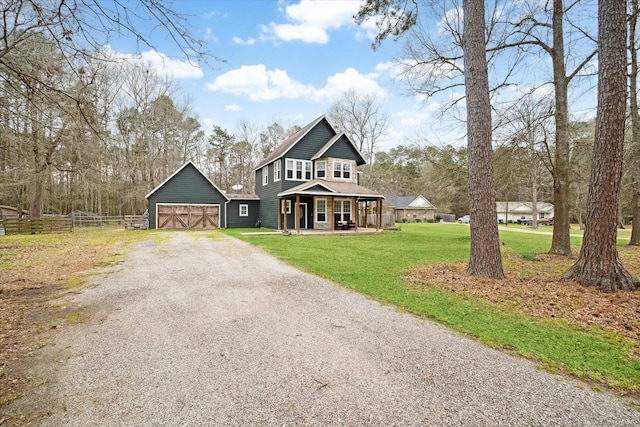 view of front facade featuring an outbuilding, a porch, fence, gravel driveway, and a front yard