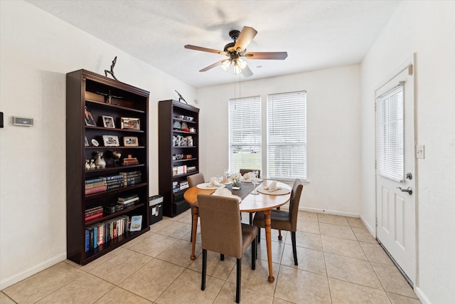 dining room with light tile patterned flooring, a ceiling fan, and baseboards