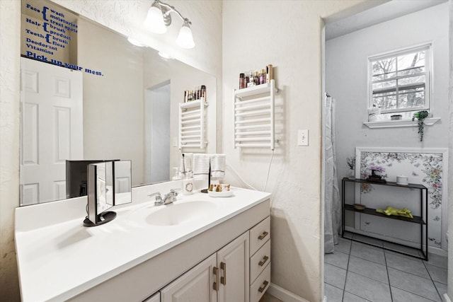 bathroom featuring tile patterned flooring, radiator, and vanity