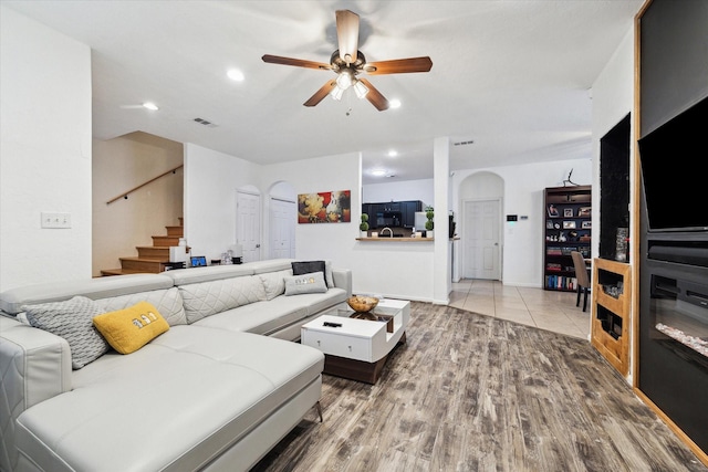 living area featuring ceiling fan, stairs, recessed lighting, wood finished floors, and arched walkways