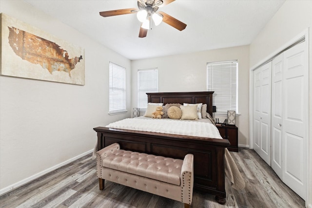 bedroom featuring a closet, a ceiling fan, baseboards, and wood finished floors