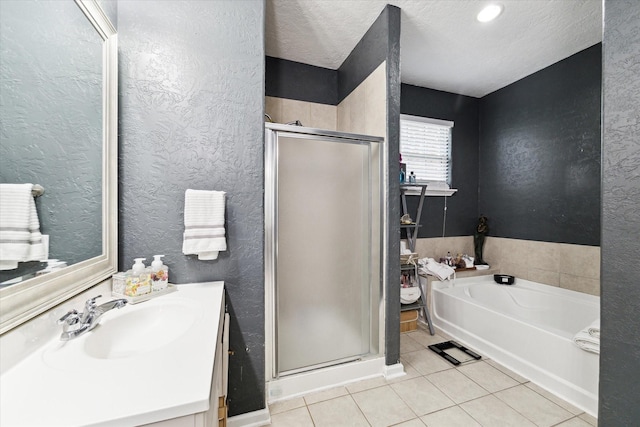 full bath featuring tile patterned flooring, a shower stall, a garden tub, and a textured wall