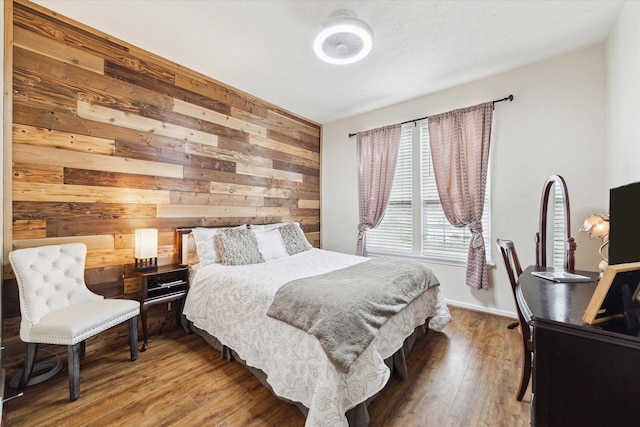 bedroom featuring wood walls and wood finished floors