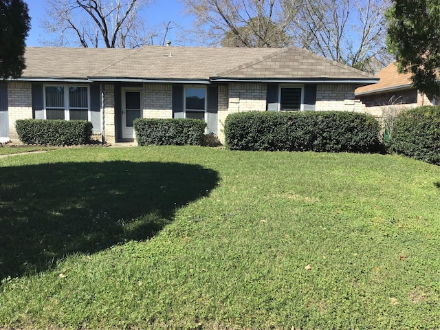 ranch-style house featuring brick siding and a front lawn