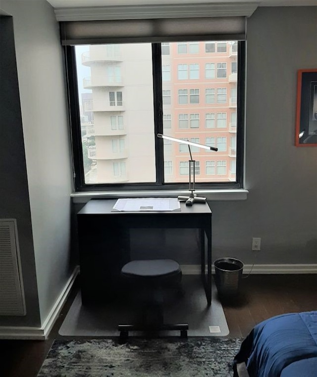 bedroom with visible vents, baseboards, and wood finished floors