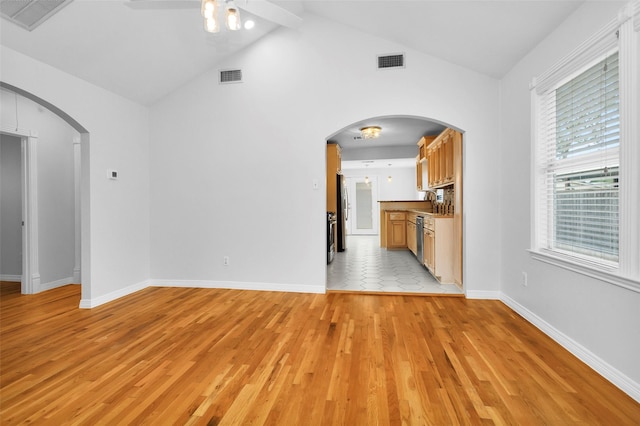 unfurnished living room with visible vents, arched walkways, and ceiling fan