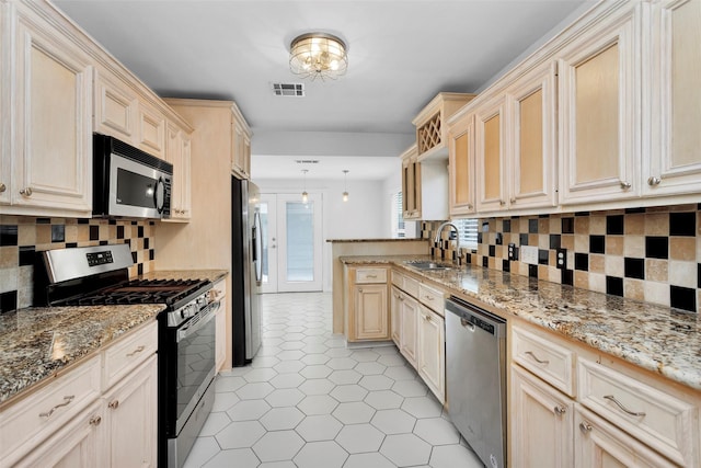 kitchen featuring visible vents, backsplash, light tile patterned floors, appliances with stainless steel finishes, and a sink