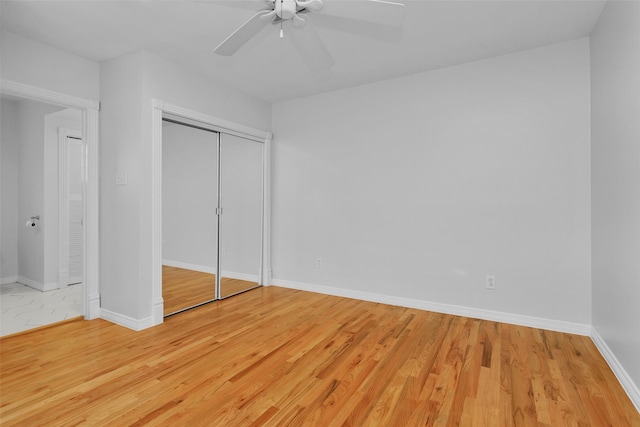 unfurnished bedroom featuring a closet, baseboards, a ceiling fan, and light wood finished floors