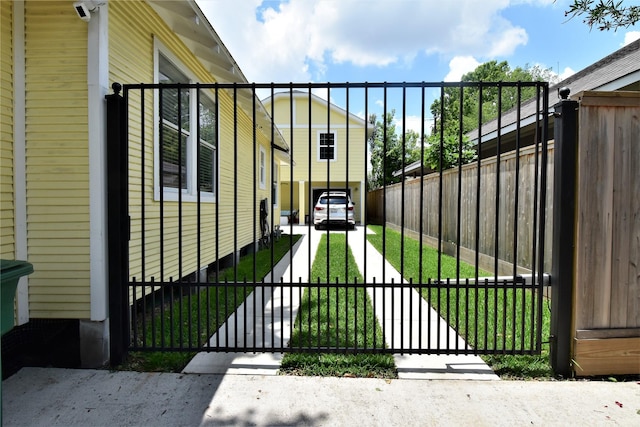 view of gate featuring a lawn and fence