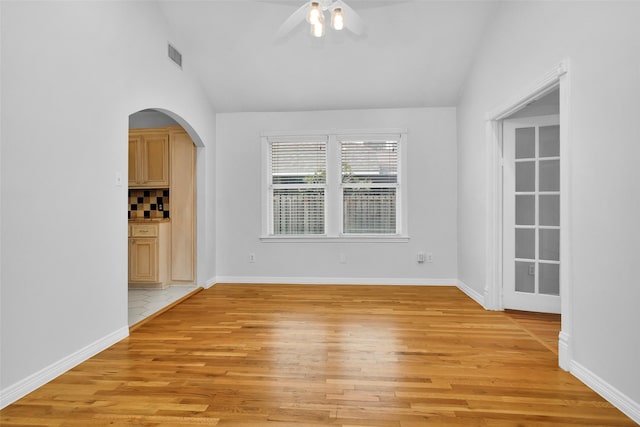 unfurnished room featuring visible vents, light wood-type flooring, lofted ceiling, and ceiling fan